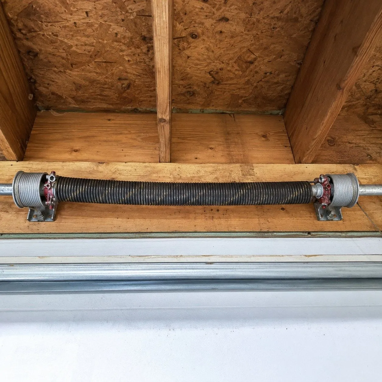 Torsion spring system above garage door